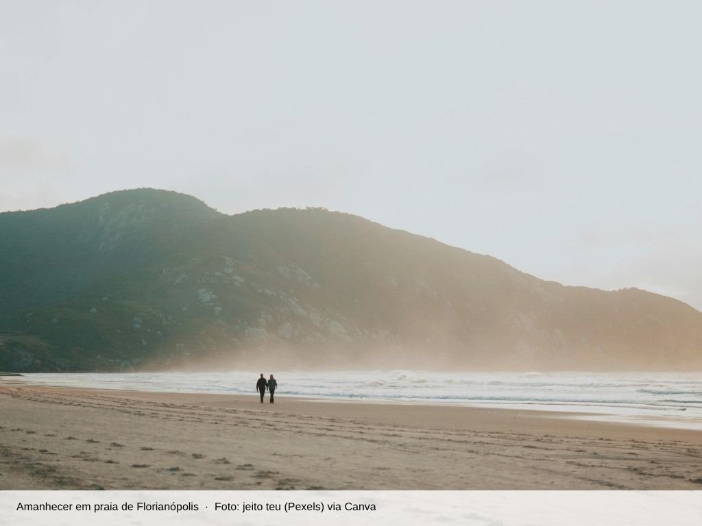Casal caminhando na praia ao amanhecer